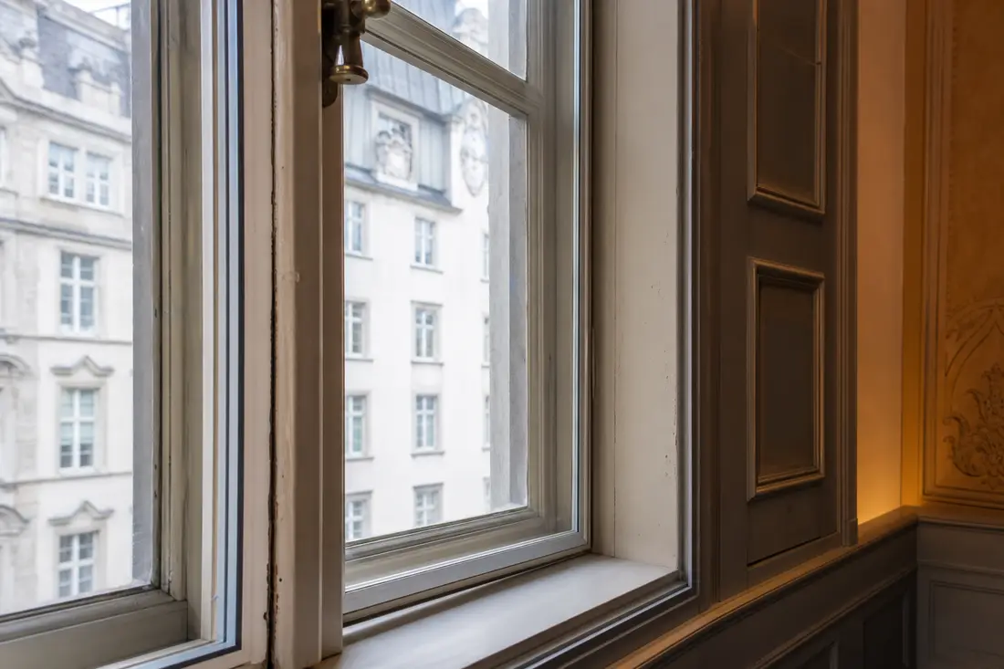Survitrage ajouté sur une fenêtre en bois ancienne lors d'une rénovation respectueuse du patrimoine